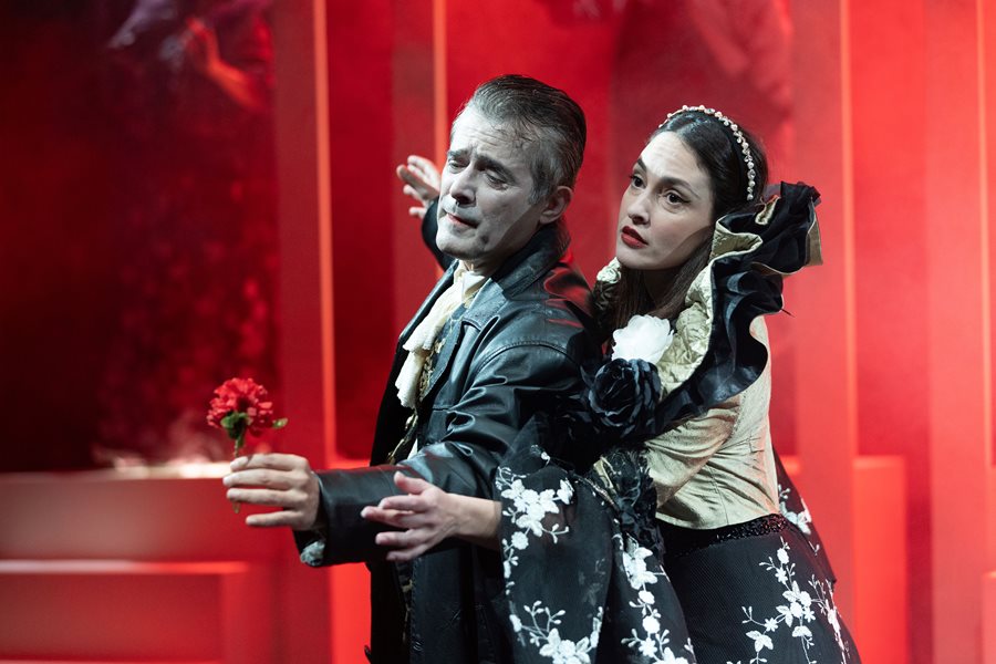 Άνδρας και γυναίκα σε σκηνή θεατρικής παράστασης "Ο Μισάνθρωπος" του Μολιέρου, με έντονα συναισθήματ.