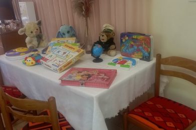 Αντικείμενα παιχνιδιού και βιβλία σε παιδικό τραπέζι, ιδανικό για δραστηριότητες και διασκέδαση παιδ.