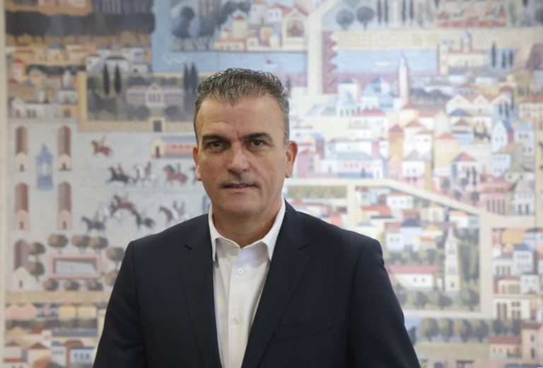 Ο Δήμαρχος Λαρισαίων Αθανάσιος Μαμάκος στο γραφείο του, μπροστά από τον πίνακα του Αστεριάδη