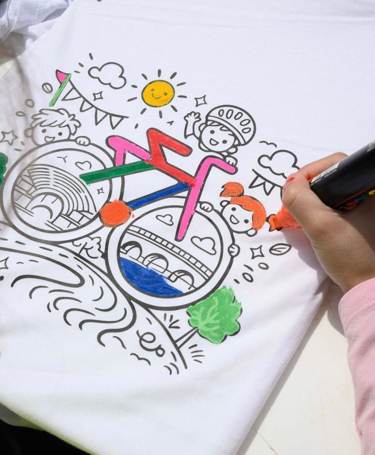 Παιδί γεμίζει με χρωματιστούς μαρκαδόρους ποδηλατικό θέμα επάνω σε ύφασμα