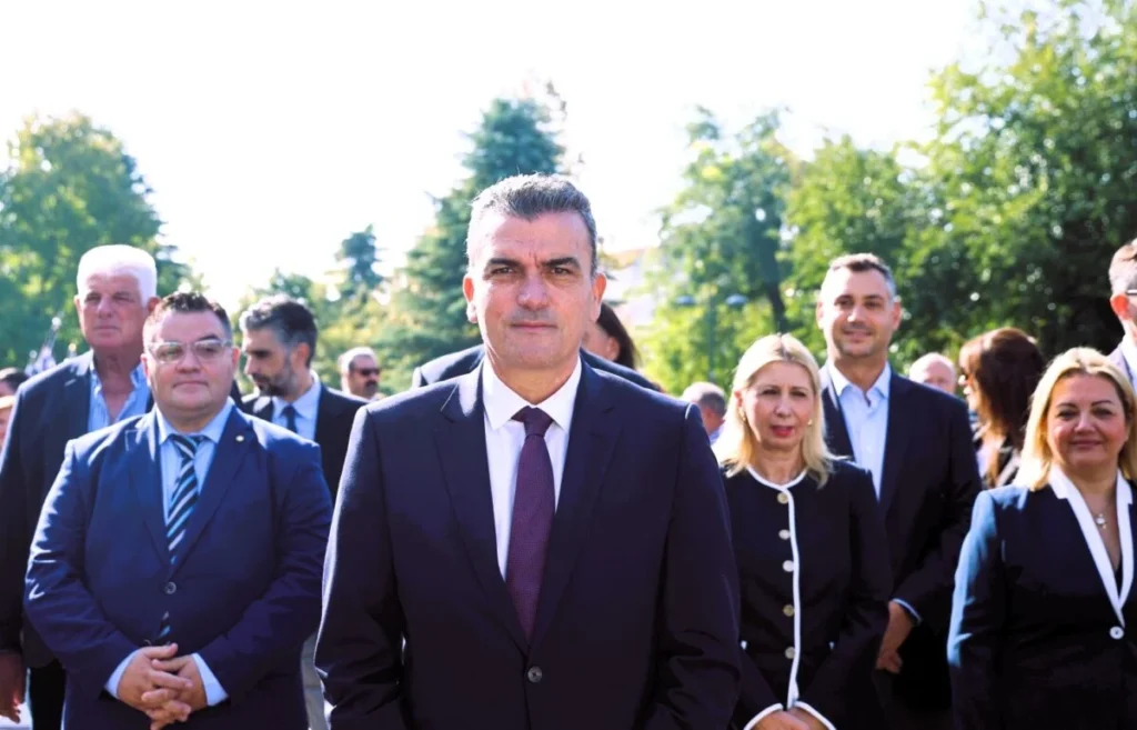 Ο Δήμαρχος Λαρισαίων Αθανάσιος Μαμάκος όρθιος μπροστά από μέλη της Δημοτικής Αρχής, στο Ηρώο της Λάρισας.