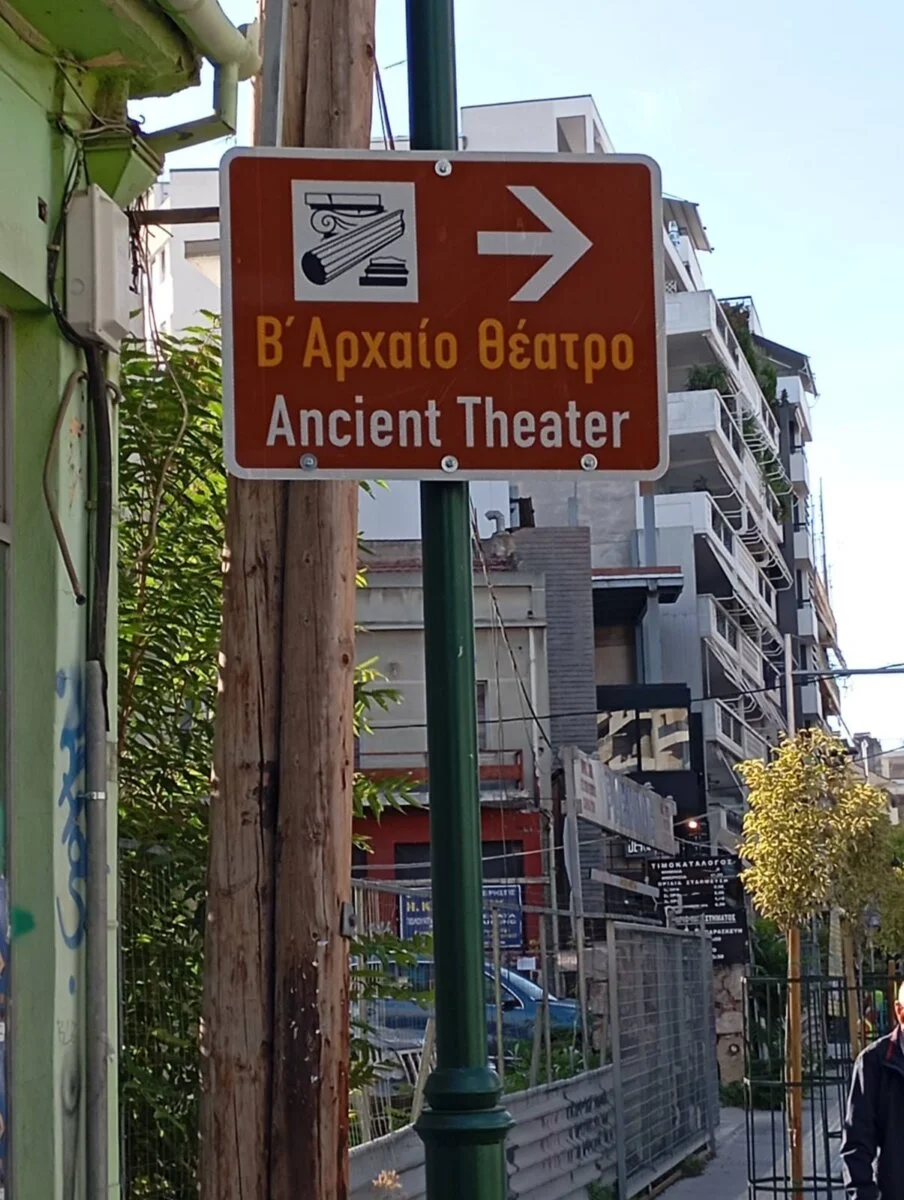 Πληροφοριακή Πινακίδα (καφέ χρώματος) για την κατεύθυνση προς το Β’ Αρχαίο Θέατρο.